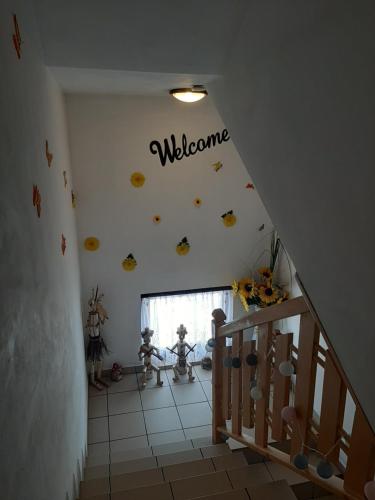 a room with a staircase with a welcome sign on the wall at Czarne jagody in Kościelisko