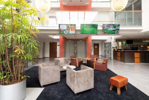a lobby with chairs and tables in a building at Seminaris Hotel Bad Boll in Bad Boll