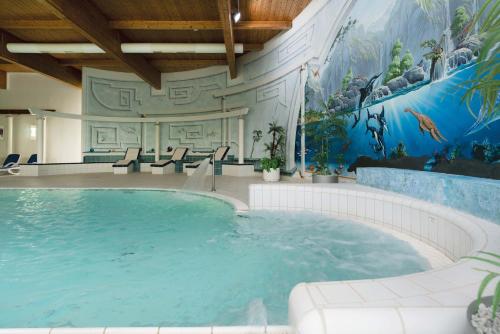 a large swimming pool in a hotel with a mural at Seminaris Hotel Bad Boll in Bad Boll