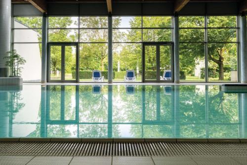 una piscina cubierta con 2 sillas en un edificio en Seminaris Hotel Bad Boll, en Bad Boll