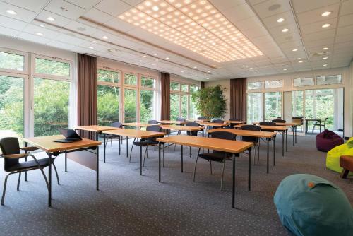 a classroom with tables and chairs and windows at Seminaris Hotel Bad Boll in Bad Boll