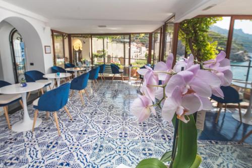 a room with tables and chairs and purple flowers at Palazzo Vingius in Minori