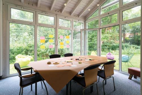a dining room with a table and chairs and windows at Seminaris Hotel Bad Boll in Bad Boll