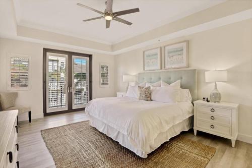 a white bedroom with a bed and a ceiling fan at Esplanade II 306 in Marco Island