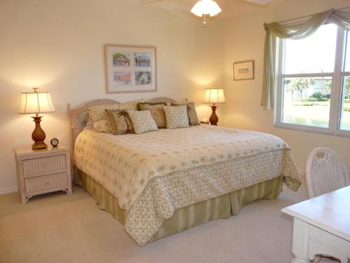 a bedroom with a bed with two lamps and a window at Quiet, gated community with pool and tennis courts in Marco Island