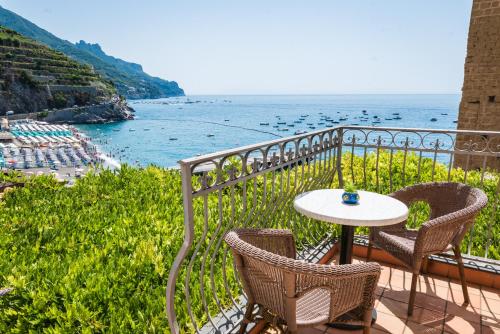 a table and chairs on a balcony overlooking the ocean at Palazzo Vingius in Minori