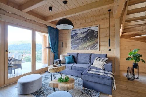 a living room with a blue couch and a table at Osada Bachledzki Wierch Odkryj Zakopane in Zakopane