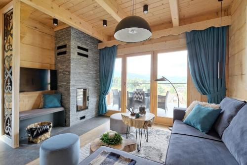 a living room with a couch and a fireplace at Osada Bachledzki Wierch Odkryj Zakopane in Zakopane