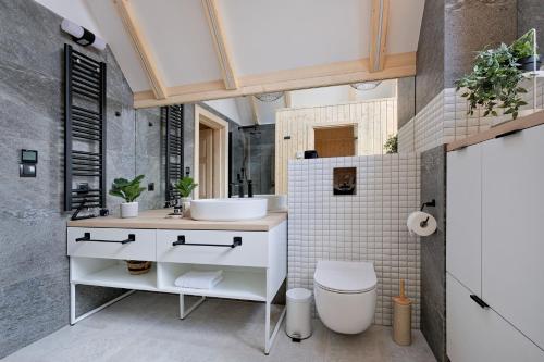 a bathroom with a white sink and a toilet at Osada Bachledzki Wierch Odkryj Zakopane in Zakopane