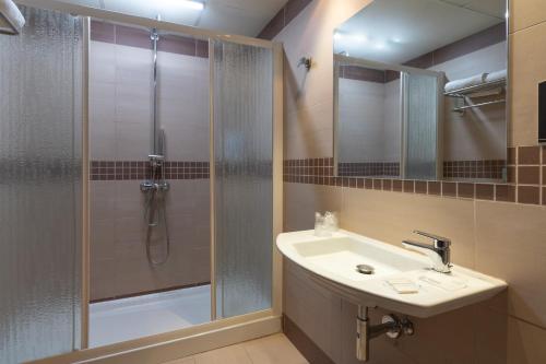a bathroom with a shower, sink, and mirror at Hotel Alda Zaragoza Independencia in Zaragoza