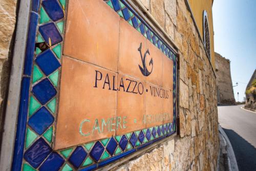a sign on the side of a building with stained glass at Palazzo Vingius in Minori