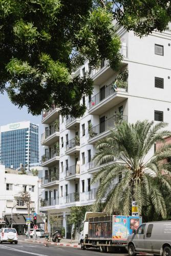 a truck parked in front of a tall white building at AYA Boutique Aparthotel in Tel Aviv
