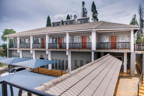 una grande casa con balcone e tetto di Khayalami Hotel - Ermelo a Ermelo