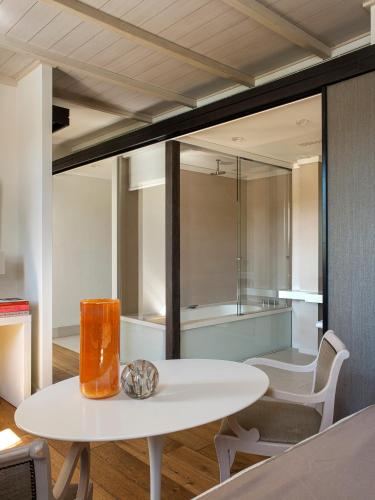 a white table and chairs in a room with a bathroom at Villa Agrippina Gran Meliá – The Leading Hotels of the World in Rome