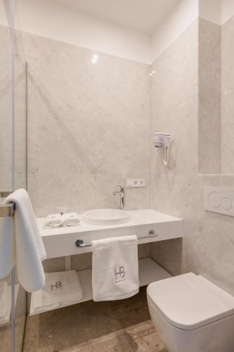 a white bathroom with a toilet and a sink at BASIS APARTMENTS - Adults Only in Kyiv