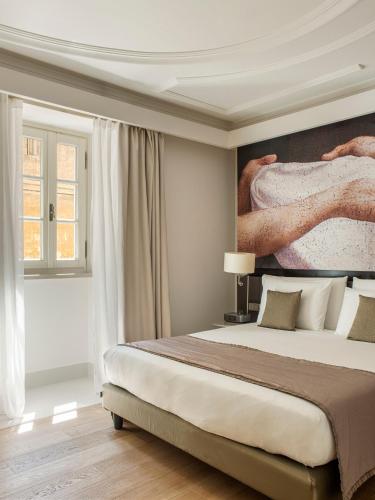 a bedroom with a large bed with a painting on the wall at Villa Agrippina Gran Meliá – The Leading Hotels of the World in Rome
