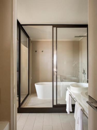 a bathroom with two sinks and a bath tub at Villa Agrippina Gran Meliá – The Leading Hotels of the World in Rome