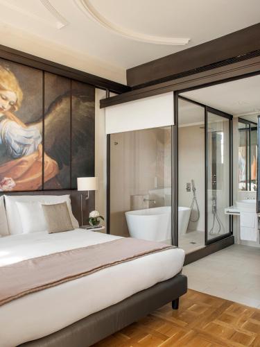 a bedroom with a large bed and a bath tub at Villa Agrippina Gran Meliá – The Leading Hotels of the World in Rome