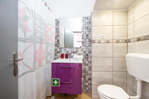 baño con aseo púrpura y lavamanos en Caparica Luxury Apartment by HOST-POINT, en Costa da Caparica