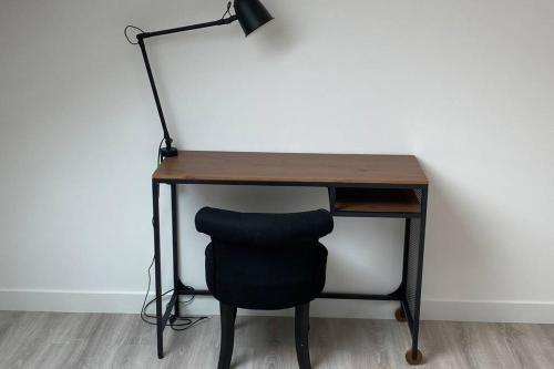 een bureau met een zwarte stoel en een lamp bij Duplex 70m2 - Parking privé - Reims Arena - Lycée Roosevelt in Reims