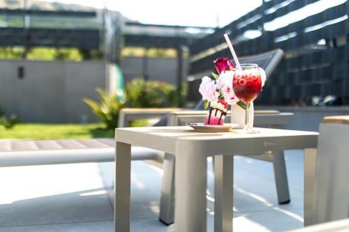 a white table with a drink and flowers on it at Villa Aurora in Baška