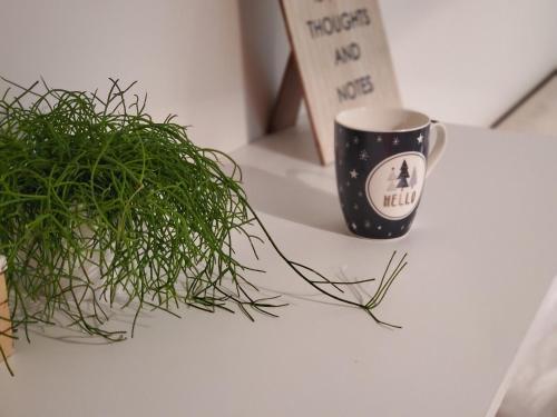 a coffee cup sitting on a table next to a plant at Sleep and drive Suites in Sarajevo
