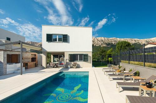 a villa with a swimming pool and a house at Villa Aurora in Baška