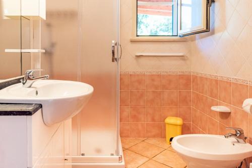 a bathroom with a sink and a toilet and a window at Villa Vanessa in Leuca