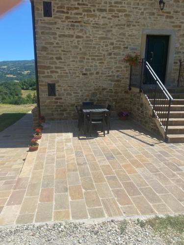 a patio with a table and a stairs and a building at Agriturismo Il Casone in San Benedetto Val di Sambro