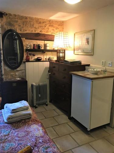 une cuisine avec un évier et une table avec une lampe dans l'établissement Chambres d'hotes Les Coustilles, à Saint-Alvère