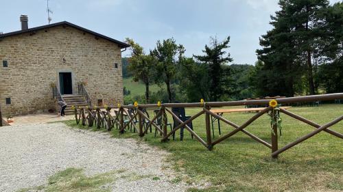 a wooden fence in front of a brick building at Agriturismo Il Casone in San Benedetto Val di Sambro
