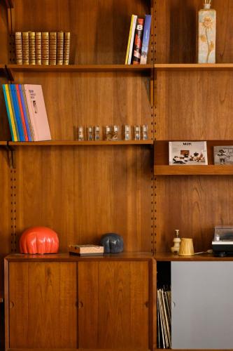 a wooden book shelf with books on it at Hôtel La Nouvelle République & Hammam in Paris
