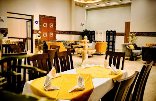 a restaurant with two tables with yellow table cloth at EL MOUSSAFIR HOTEL in Marrakesh