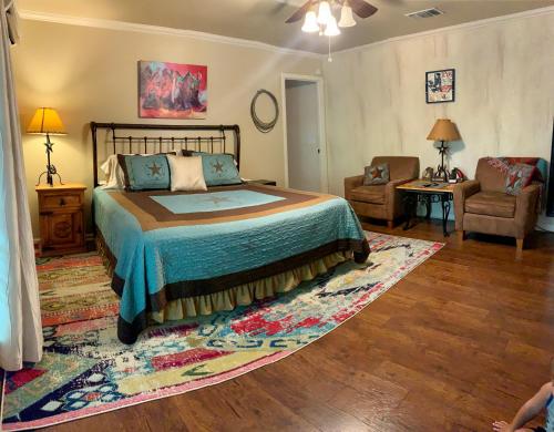 a bedroom with a bed and a couch and a chair at Lamb's Rest Inn in New Braunfels