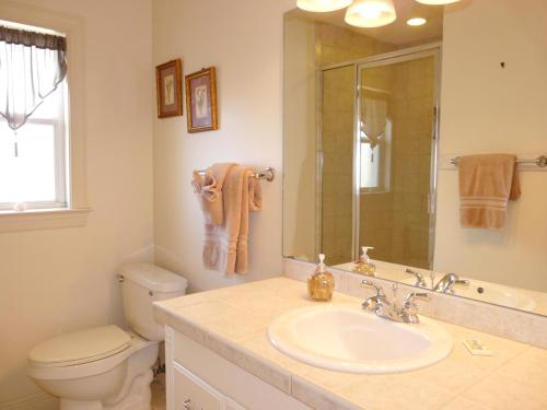 a bathroom with a sink and a toilet and a mirror at 438 Kendall Drive in Marco Island