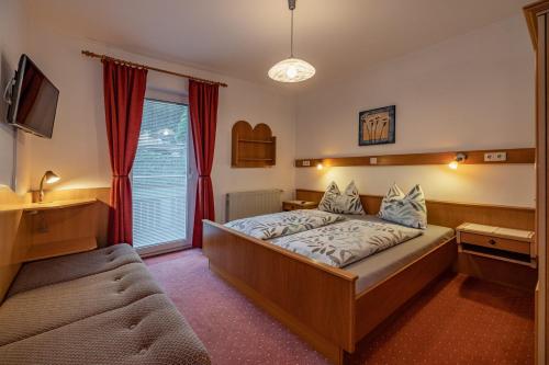 um quarto de hotel com uma cama e uma janela em Gästehaus Eder em Tröpolach