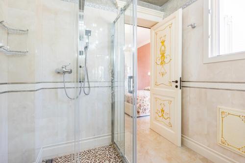a bathroom with a shower and a glass door at Villa Vanessa in Leuca
