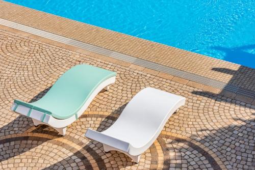 two lounge chairs next to a swimming pool at Villa Vanessa in Leuca