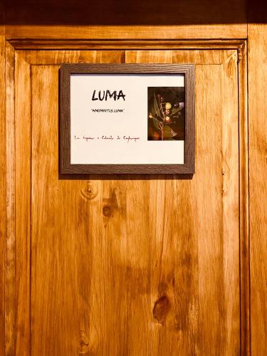 a picture on a wooden wall with a sign on it at Hostal Esquina Patagónica in Coihaique