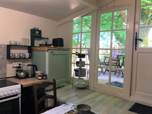 une cuisine avec une porte ouverte sur un patio dans l'établissement Chambres d'hotes Les Coustilles, à Saint-Alvère