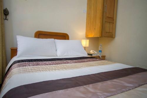 Łóżko lub łóżka w pokoju w obiekcie Crown Suites Ltd Mbale