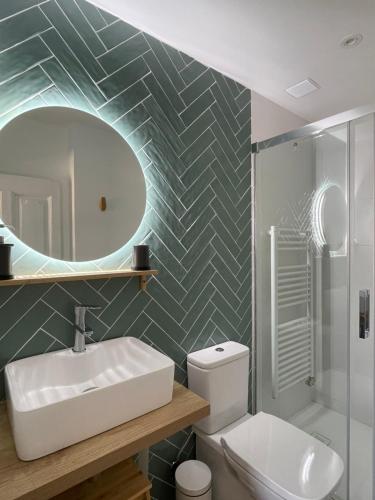 ein Badezimmer mit einem Waschbecken, einem WC und einem Spiegel in der Unterkunft Hotel Rural El Cedro in Lerma