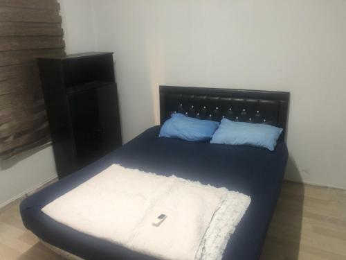 1 cama pequeña con 2 almohadas azules en AVRUPA APART HOSTEL, en Seyhan