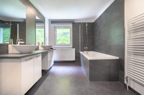 a bathroom with two sinks and a bath tub at Urlaubsplatzl Appartements in Oetz