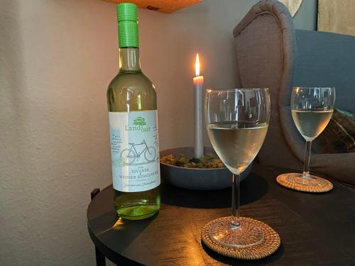 - une bouteille de vin assise sur une table avec deux verres dans l'établissement Ferienwohnung Gipfelglück zwischen Bikepark & Skipiste, à Winterberg