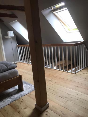 a attic room with a crib and a skylight at Fachwerk-Maisonette-Wohnung -zur Tenne- in Rieste