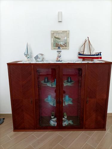 a wooden cabinet with glass doors in a room at Il vicolo di Clara B&B in Diamante