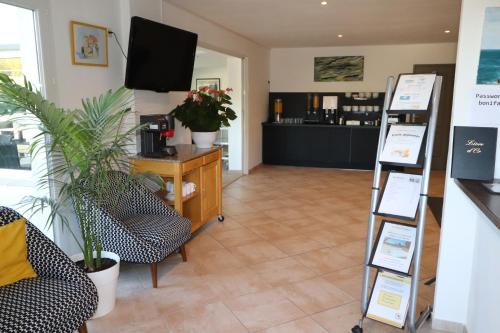 een woonkamer met 2 stoelen en een televisie bij Hôtel Padolo in Bonifacio