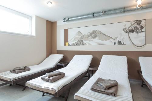 a room with three beds and a picture of a mountain at Landhaus Fiegl in Sölden