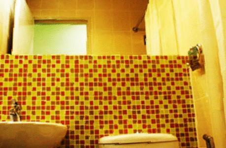 uma casa de banho com um WC e uma parede em azulejo em YY38 Hotel em Kuala Lumpur